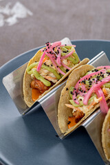 Homemade shrimp tacos with coleslaw and salsa served on a blue plate