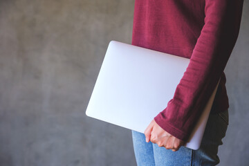 Closeup image of a woman holding laptop computer