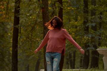 young woman in casual clothes is relaxing in an old park