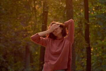 A woman in Casual clothes does yoga in an old park