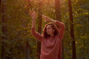 young woman in casual clothes is relaxing in an old park