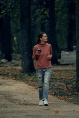 young woman in casual clothes is relaxing in an old park