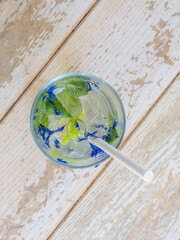 Top view of drink in a glass with a straw with wood background