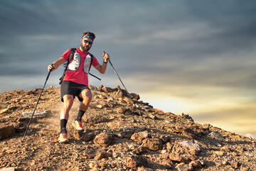 Sporty man descends from rocky peak