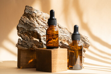 Two amber glass bottles with facial serum in sunlight on wooden 3d podium. Packaging for cosmetics...