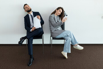 office employees sit on chairs man and woman waiting for an interview