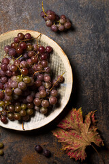 Ripe, organic grapes in a plate on a metal background