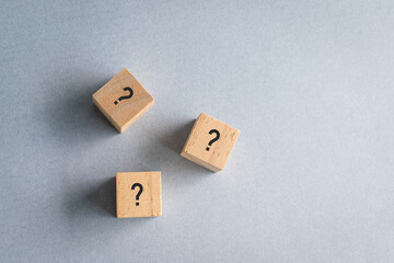 Three wooden cube block shape with sign question mark on them. Top view.