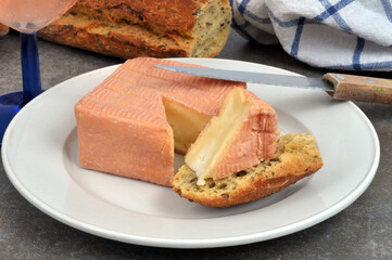 Portion de fromage Maroilles sur un morceau de pain dans une assiette avec un couteau en gros plan