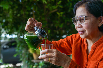 hand holding a jug of plant smoothie poured into a glass