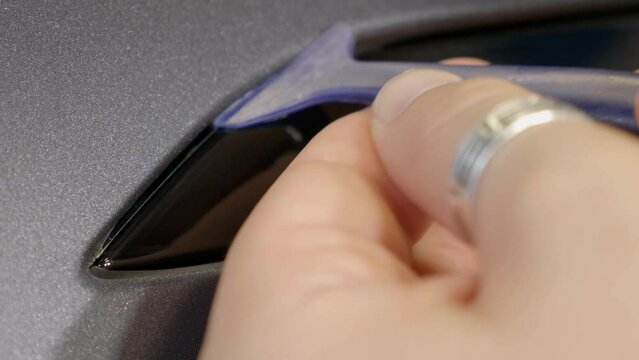Pressing in Car Wrapping Foil in Small Seam with Plastic Tool Close Up