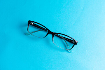 Top view round black Eye Glasses on blue Background