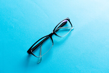 Top view round black Eye Glasses on blue Background