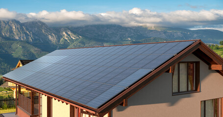 Photovoltaic panels on the roof of a modern house in the mountains