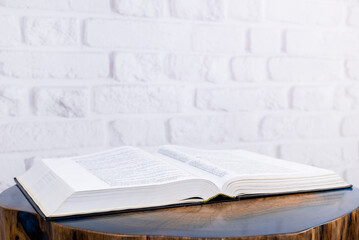 The book is on the table. Open Holy Bible. Decorative wooden table.