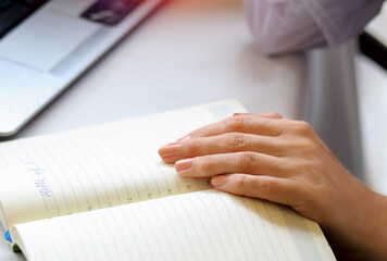Woman's hand on a notebook sitting at the arrow. Letter. Training. Study concept.