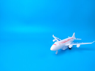 Fototapeta na wymiar White toy airplane on a blue background with copy space.