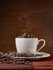 Coffee cup and coffee beans on a wooden background. View from above.