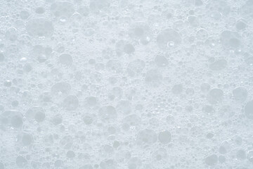 White foam texture. Soapy liquid. Skin care cleansing cosmetic in top view. Cleanser or shampoo...
