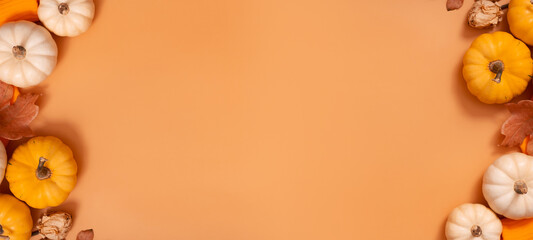 Autumn banner with flat lay composition from pumpkins and fallen leaves and sweater with space for text