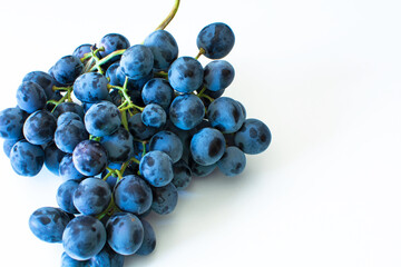 A bunch of grapes on a wooden white background.Red wine grapes.