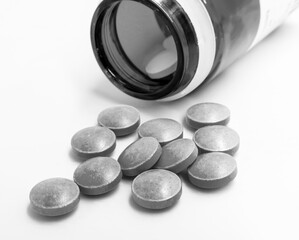 Fiolka z rozsypanymi niebieskimi lekami czarno-białe zdjęcie