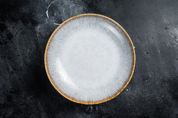 Food cooking background, empty white craft plate on table. Table setting. Black background. Top...