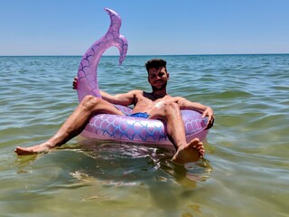 man posing on the sea in Portugal on his inflatable rubber part