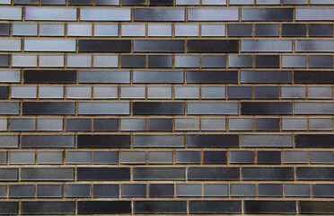 A section of a wall lined with bricks of gray and brown shades