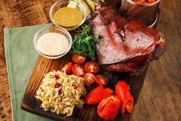 Bavarian Pork Knuckle Close-up  meat in a restaurant Baked Eisbein with wegetables on wooden board  - obrazy, fototapety, plakaty