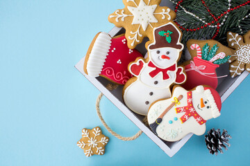 Christmas gingerbread in the white wooden tray on on the blue background. Top view. Copy space.