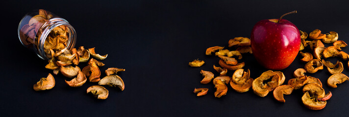 Banner. Red apple and dried chopped apples on the black background. Copy space. Close-up.