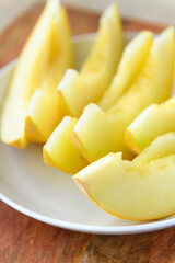 a plate full of sliced melon on a wooden board, the concept of fresh fruit and healthy food
