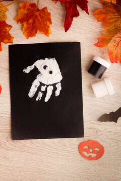 Ghost child hand print art. Easy beginner Halloween crafts . Painting for kids. Handmade party invitation, greeting card