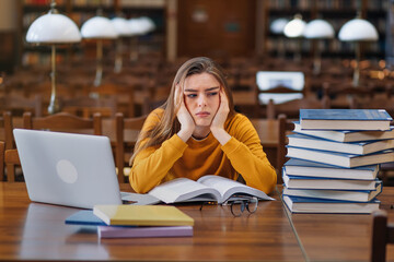 Stressed college student tired of hard learning with books and l