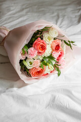 
bouquet of flowers on bed. Roses, carnations, lisianthus. 