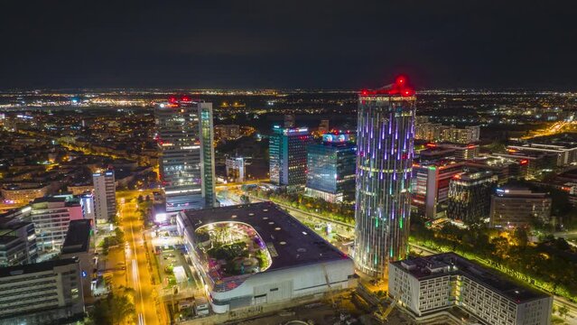 Night aerial hyperlapse of illuminated cityscape with modern Promenada Mall