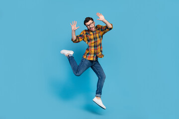 Fototapeta na wymiar Full body portrait of satisfied sportive person jumping have good mood isolated on blue color background