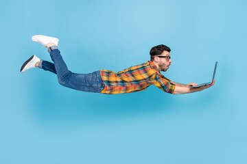 Full length profile photo of impressed person flying fall use netbook isolated on blue color background