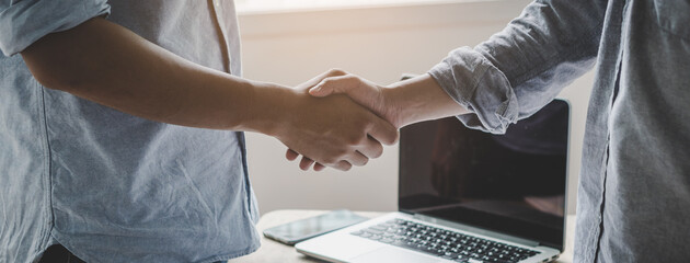 young startup businessman shaking hands with partners after agree a deal to collaborate.