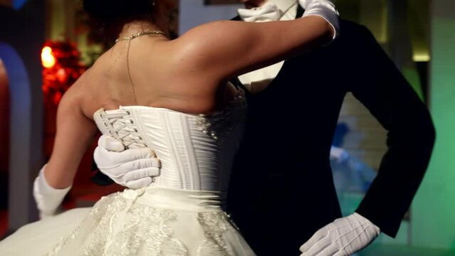 sexy busty lady is dancing waltz in embrace of handsome elegant man, happy woman in gorgeous dress