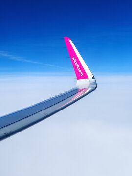 Malmo, Sweden - August 22, 2022: Left wing of WizzAir airplane after taking off above Malmo Sturup airport heading to Belgrade, Serbia