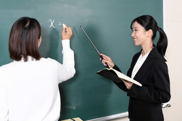 黒板の前で学生に解答させる先生