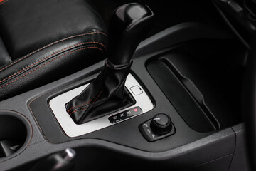 Obraz na płótnie Canvas automatic transmission shift selector in the car interior. Closeup a manual shift of modern car gear shifter. 4x4 gear shift 