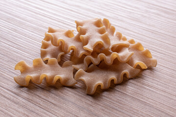 whole wheat durum wheat pasta on wooden background
