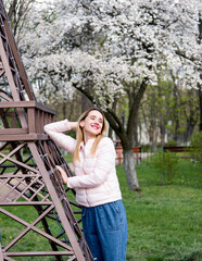 blonde girl in spring park near mini eiffel tower in Kyiv city