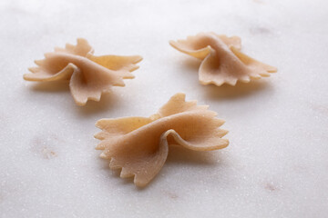 whole durum wheat pasta on white marble