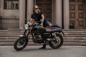 Plakat Shot of brutal motorcyclist with beard and long hairs driving motorbike.