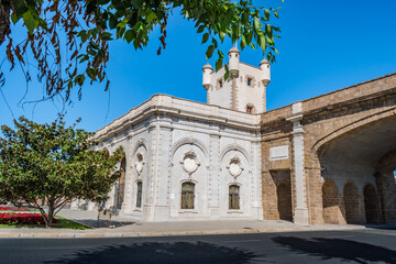 Obraz premium Decorated marble facade and turret of the Puerta de Tierra and arched wall of the old entrance to the city of Cadiz - Spain
