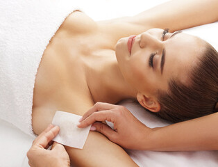 Hair removal, beauty and health concept. A young girl is getting an epilation procedure. A...